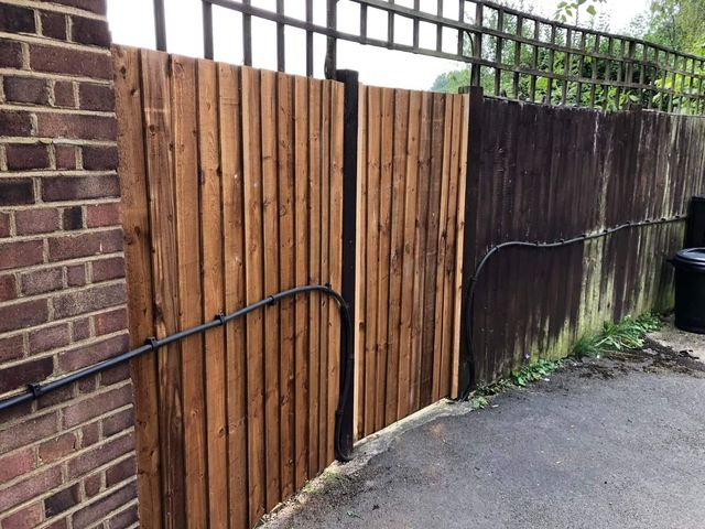 Closeboard fencing run in beside a brick pier on a driveway