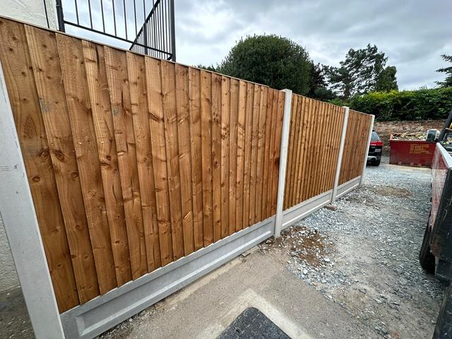 New closeboard panels on concrete posts and gravel boards beside a gravel driveway