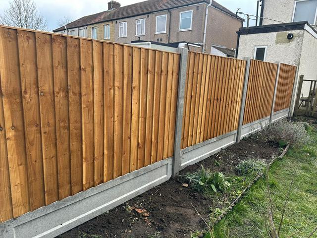 New closeboard fencing on concrete posts and gravel boards behind a flower border