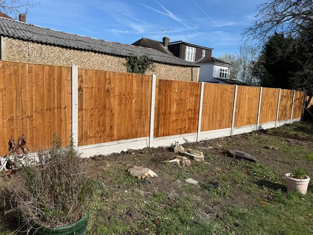 New closeboard panels on concrete posts and gravel boards alongside a garage