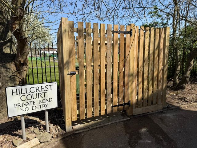 A new timber pale gate at the entrance to a private road
