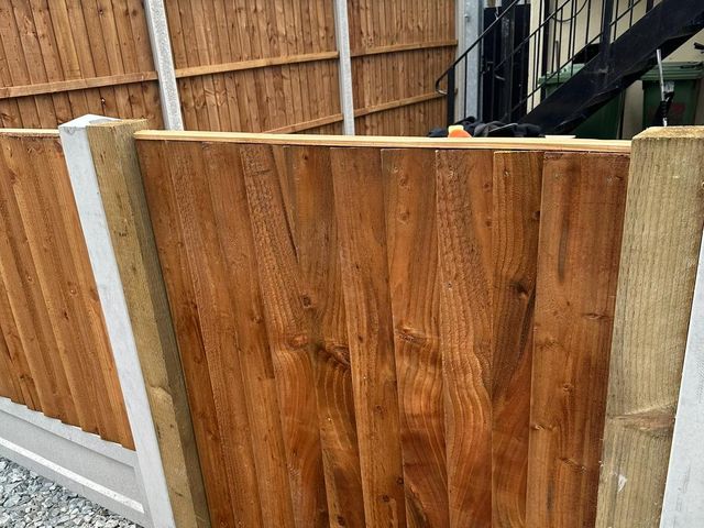 New closeboard panels meeting at a corner post on a gravelled yard