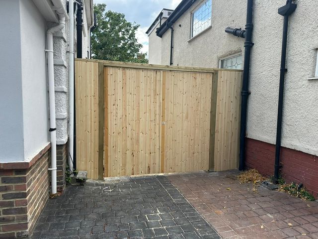 A pair of new pine gates across the side passage of a house